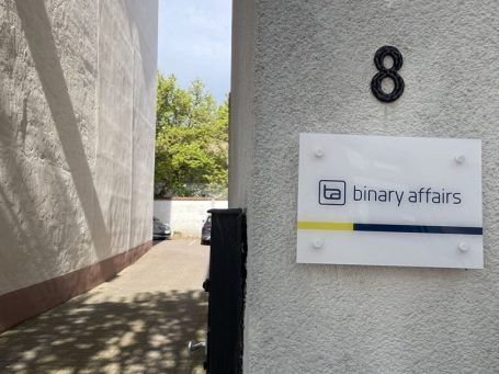 Hausecke mit der Hausnummer 8 und dem Firmenschild von binary affairs