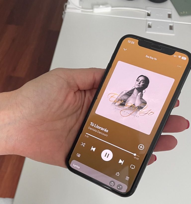 Hand hält ein Handy mit geöffneter Spotify-App